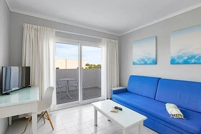 a living room with a blue couch and a white table