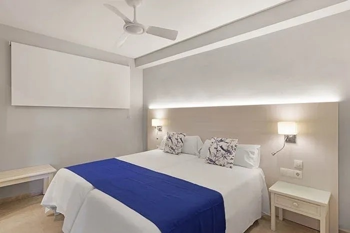 una habitación de hotel con una cama y un ventilador de techo .