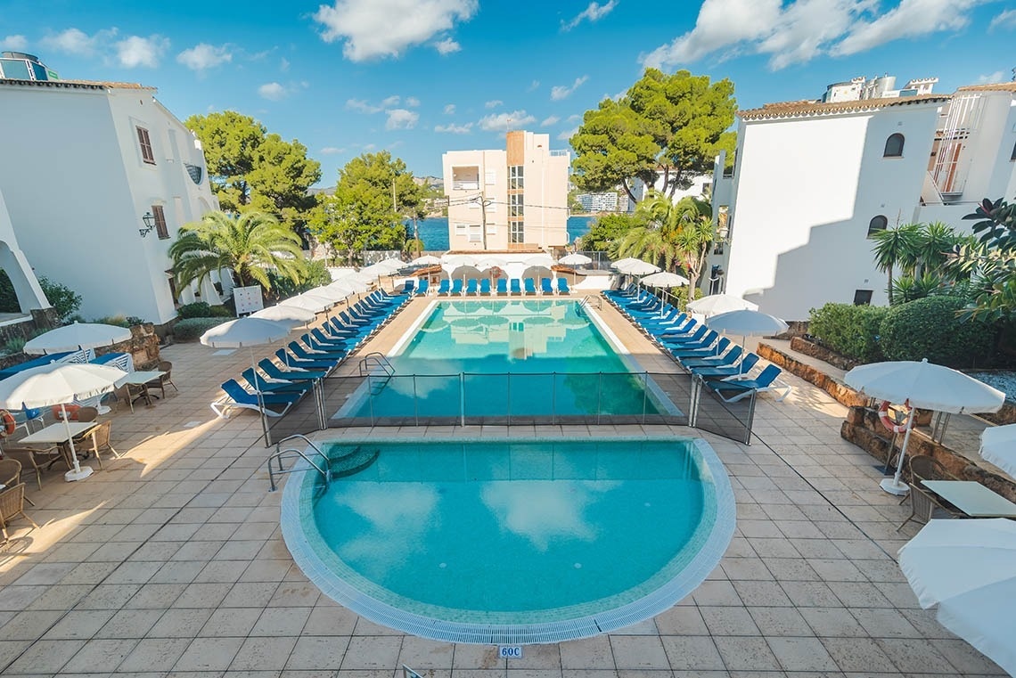 una mujer está parada en la cima de una montaña mirando al océano .