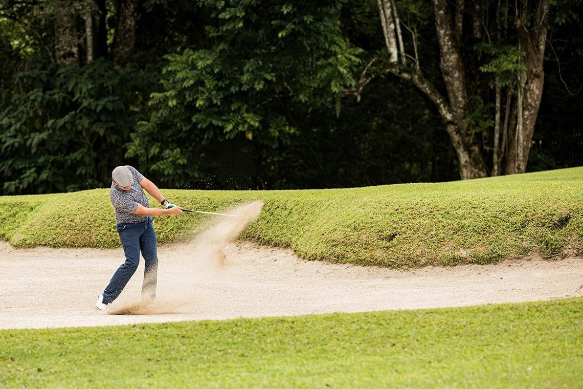 a woman is standing on top of a mountain overlooking the ocean .
