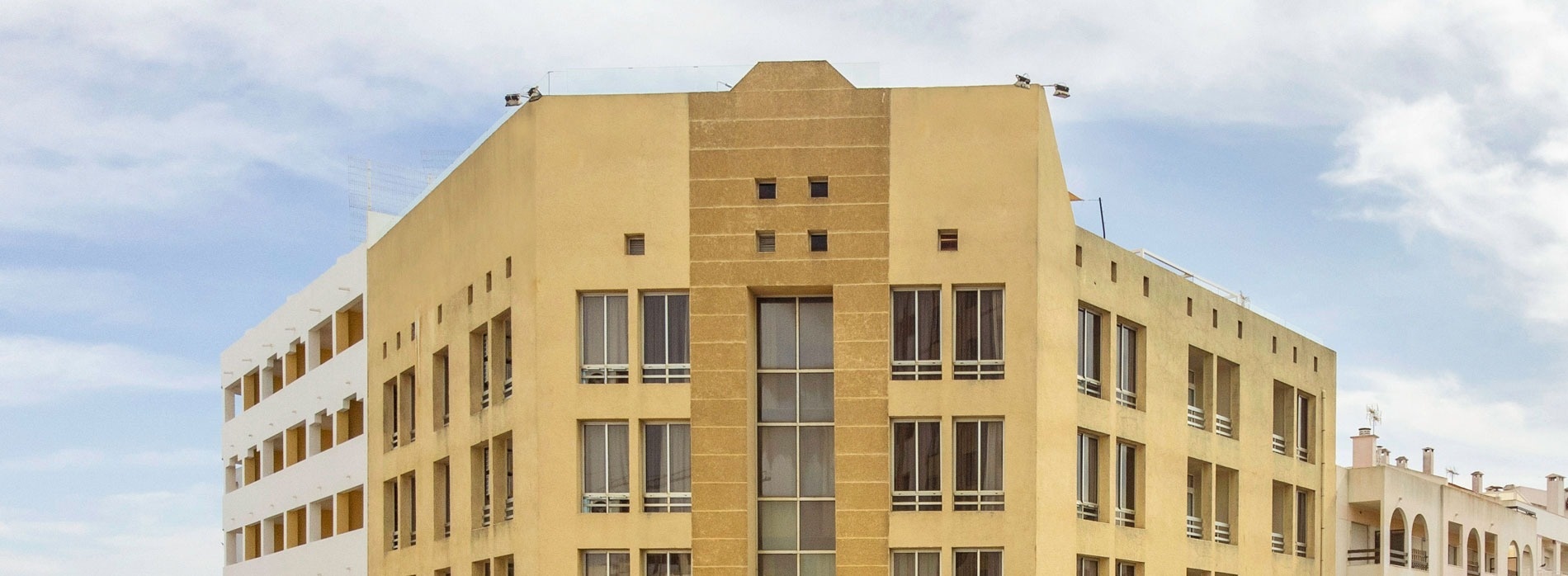 un edificio amarillo y blanco con muchas ventanas