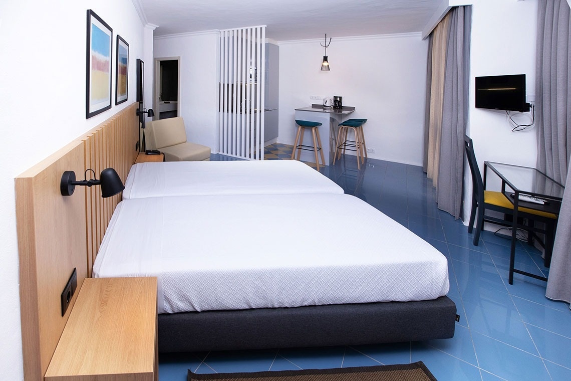 a woman in a black bathing suit is swimming under a waterfall