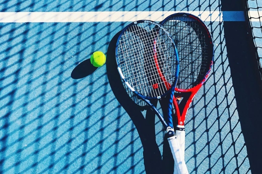 raquete de tênis e bola de tênis em uma quadra de tênis