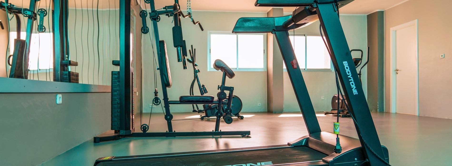 una cinta de correr bodytone está en un gimnasio