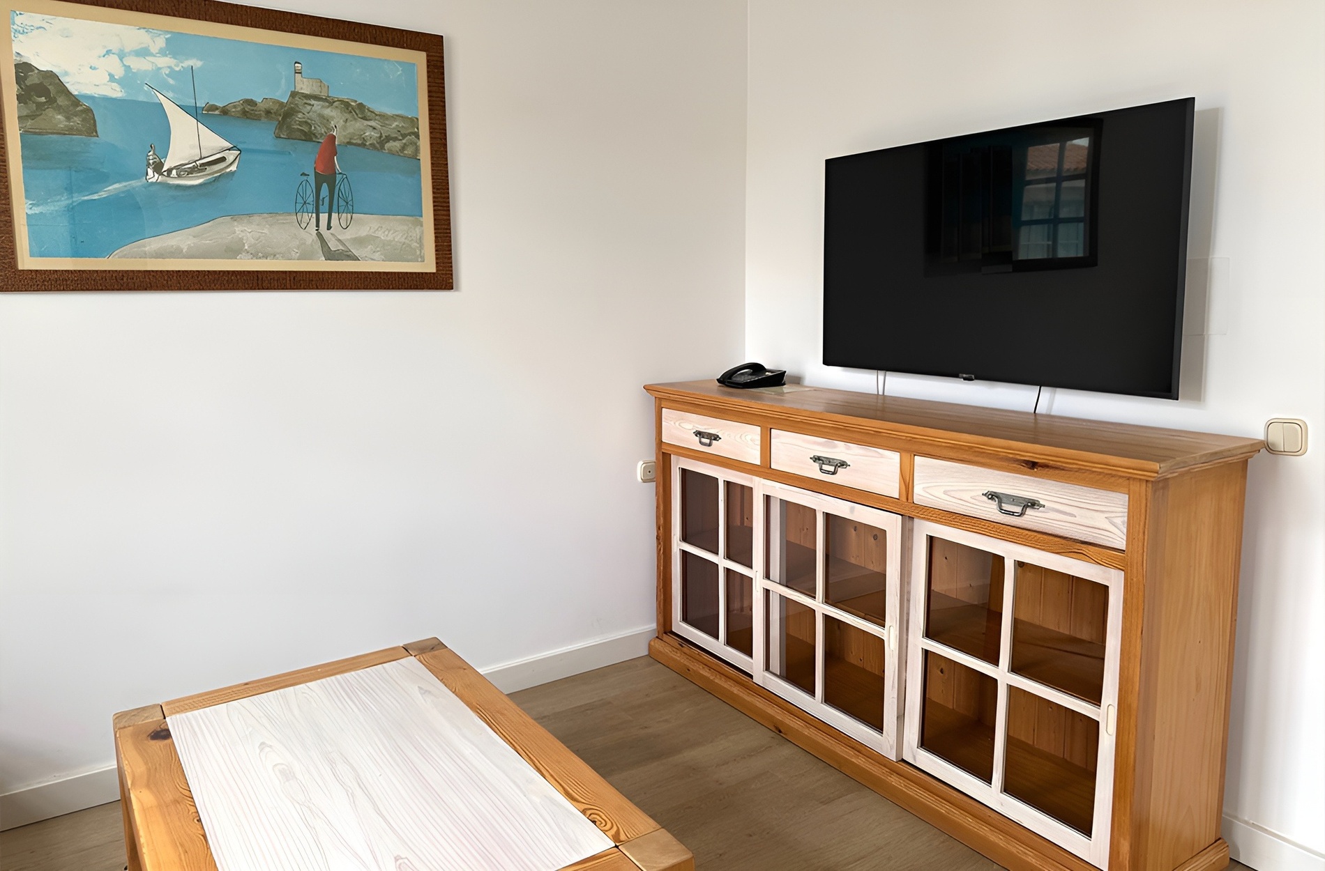 a living room with a painting on the wall above the tv