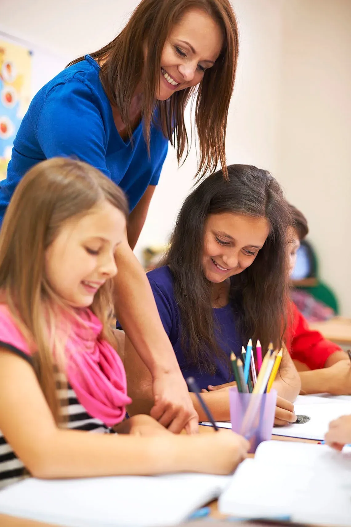 Maestra ayuda a estudiantes en clase, On Hotels: Fundacion fomenta el aprendizaje.