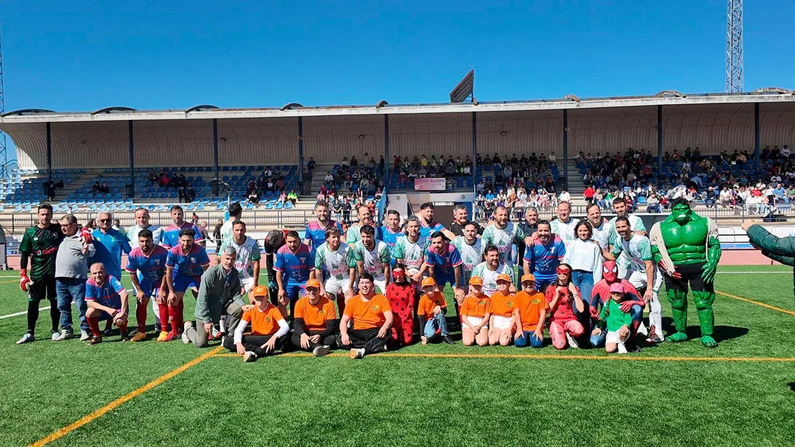 On Hotels: Fundación posa con jugadores y disfraces en campo de fútbol.