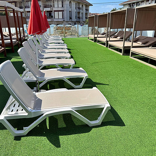 Sun loungers and cabanas on a rooftop pool deck at a Gala Noja, perfect for relaxation.