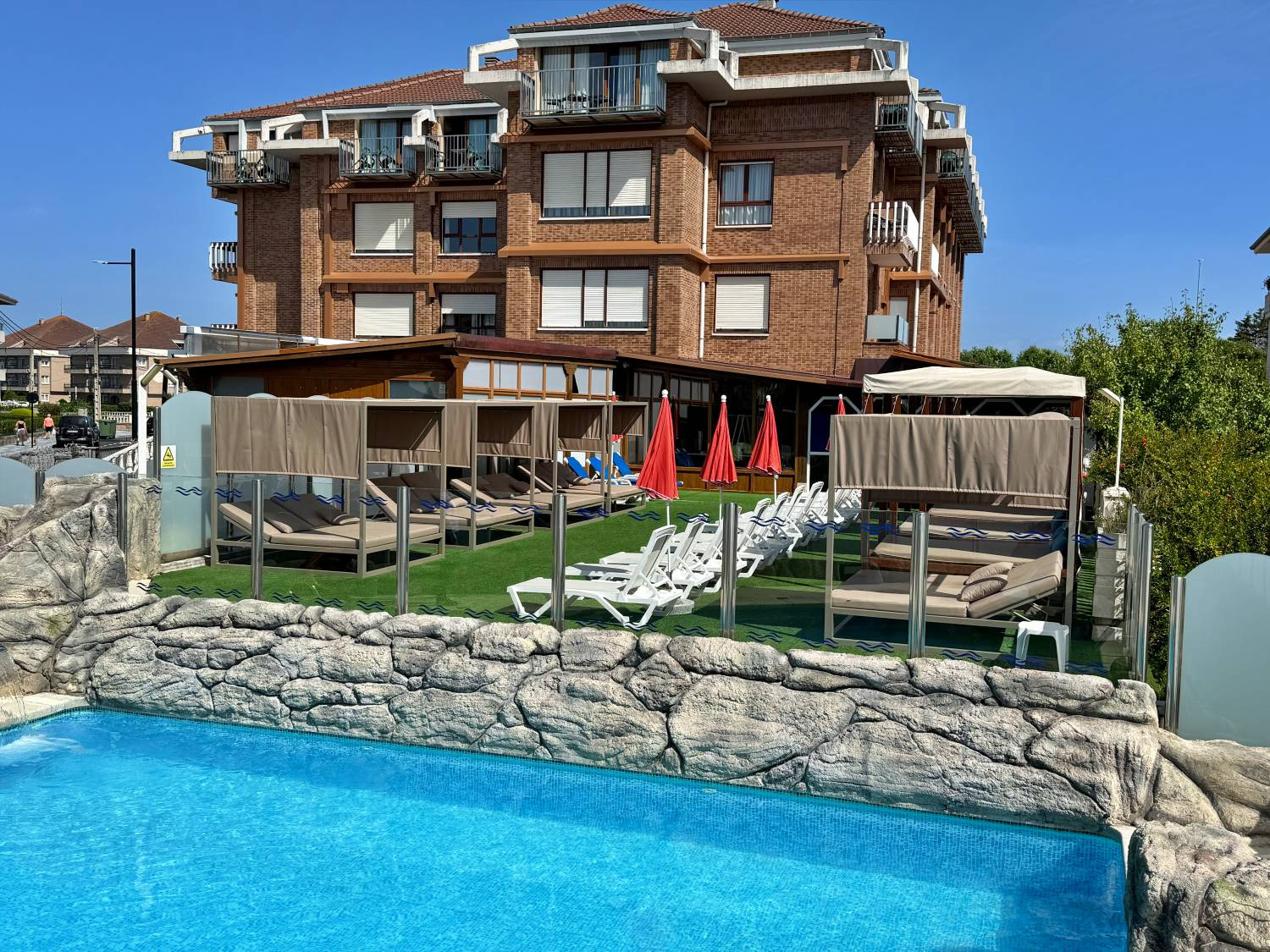 Lujosos camastros con dosel junto a la piscina del hotel, ideales para relajarse Gala Noja.