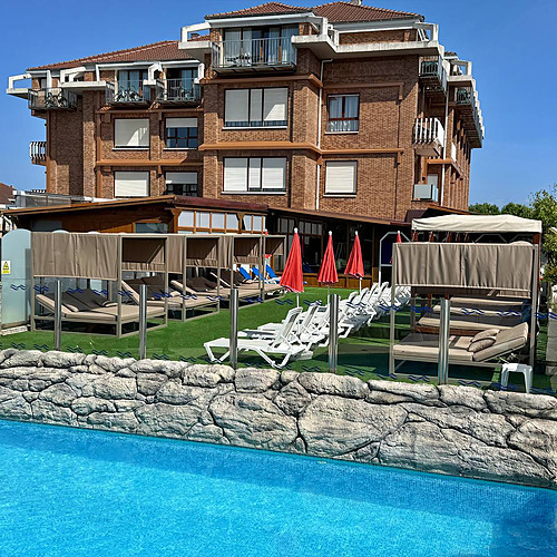 Luxury hotel pool area with lounge beds, umbrellas, and cabanas, ideal for Gala Noja.