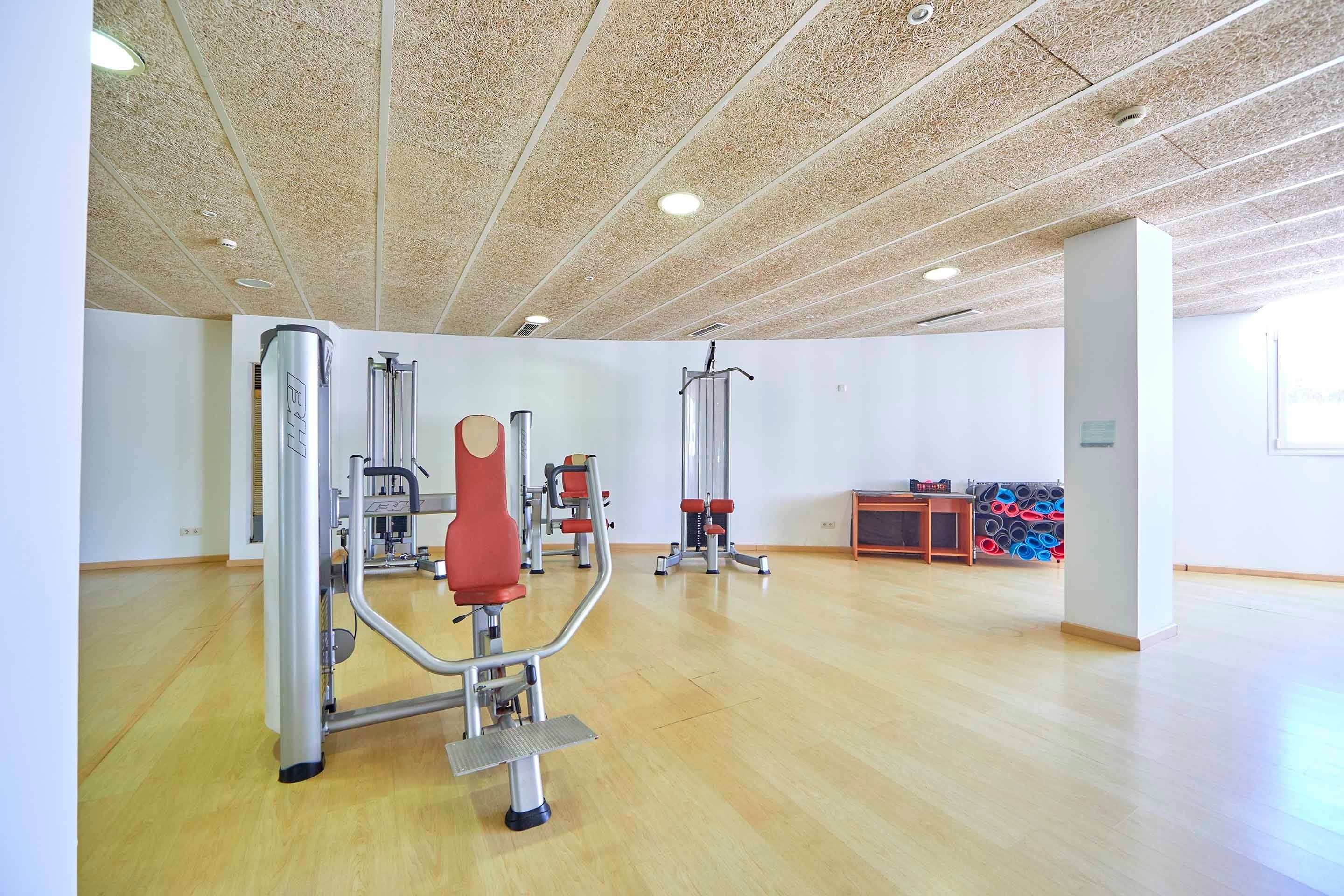 a gym with a wooden floor and a few exercise machines