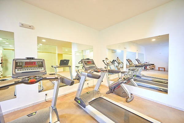 Salle de sport moderne au Gavimar La Mirada avec tapis roulants et vélos elliptiques. Idéal pour se détendre à Cala d'Or, Îles Baléares.