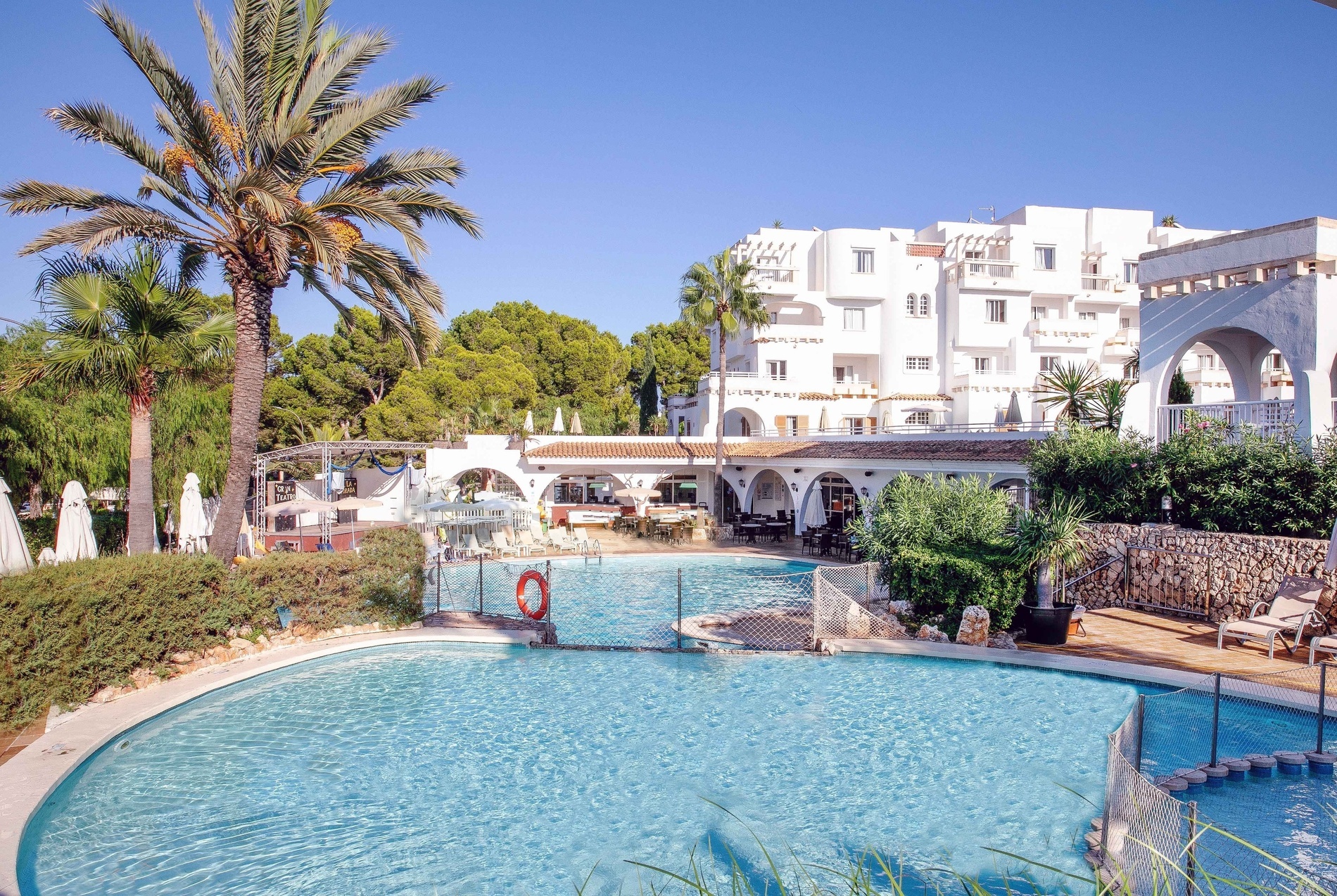 a large swimming pool in front of a white building