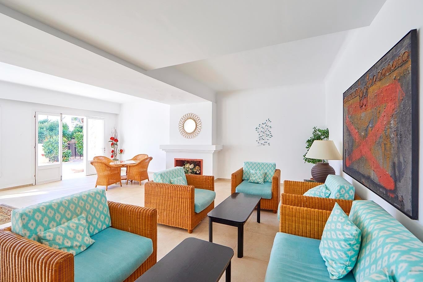 Lounge area with wicker furniture and turquoise cushions at Gavimar Cala Gran Costa del Sur.
