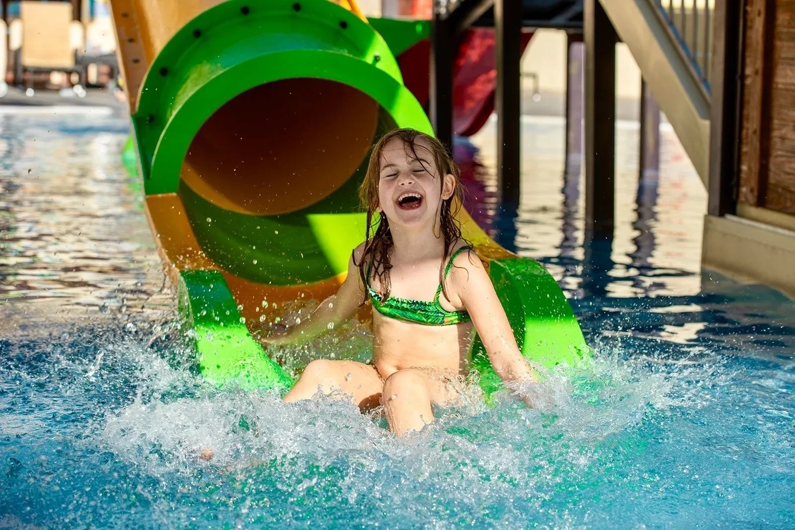 a woman in a black swimsuit sits on a surfboard in the ocean