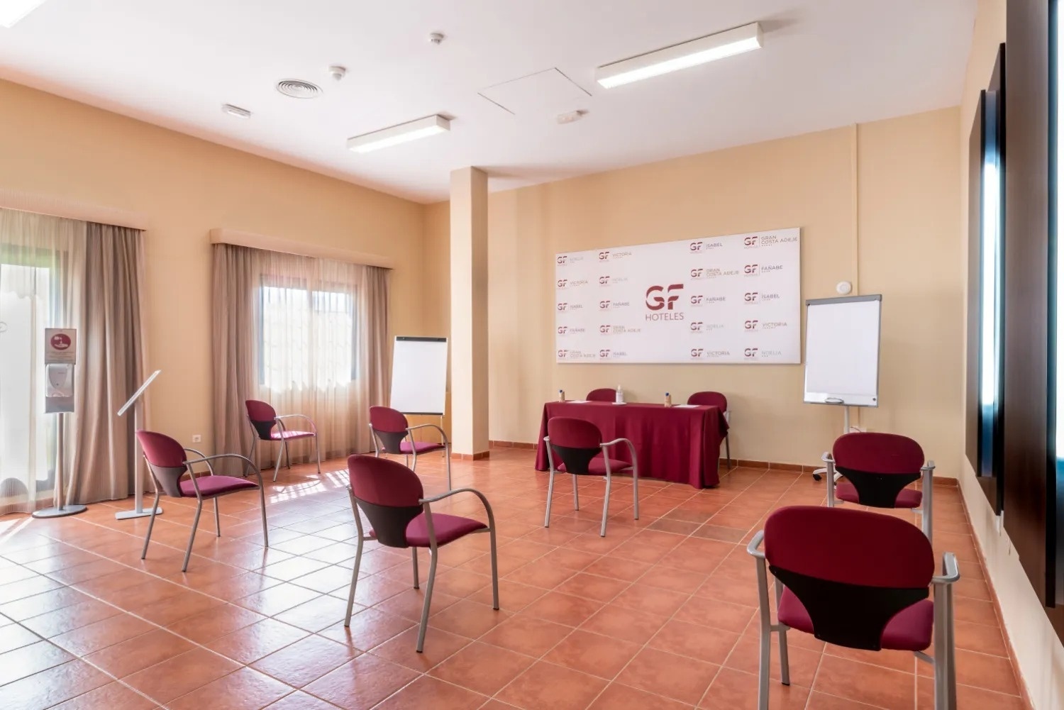 a conference room with a gf hoteles sign on the wall