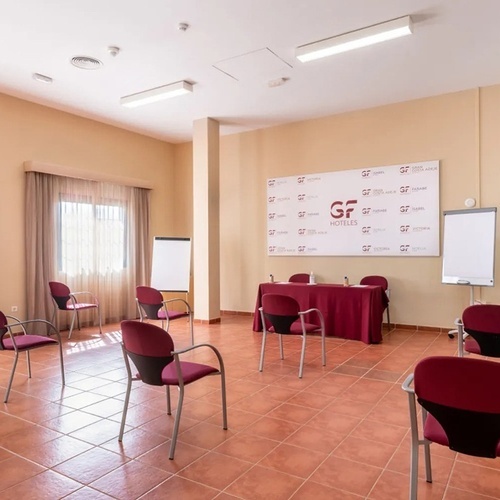 a conference room with a gf hoteles sign on the wall