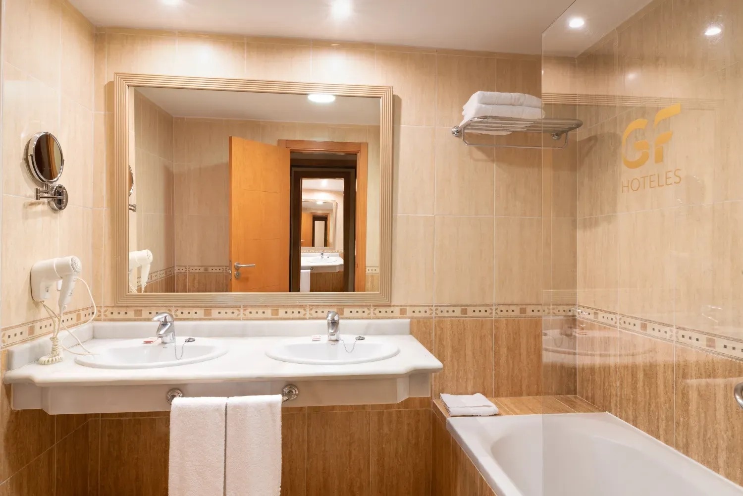 un baño de hotel con dos lavabos y una bañera