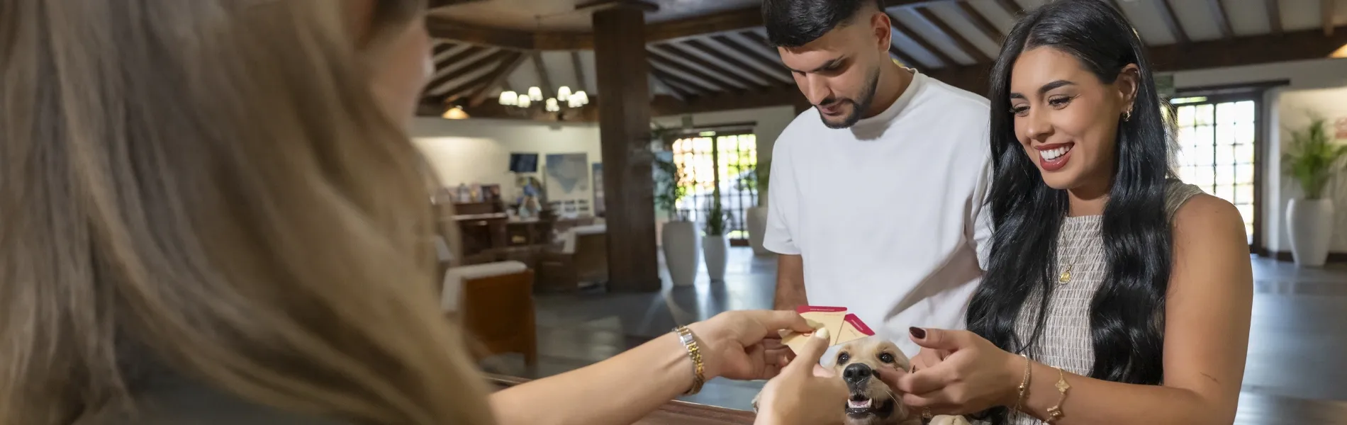Couple checking into a GF: Corporativa with their dog at the reception desk.