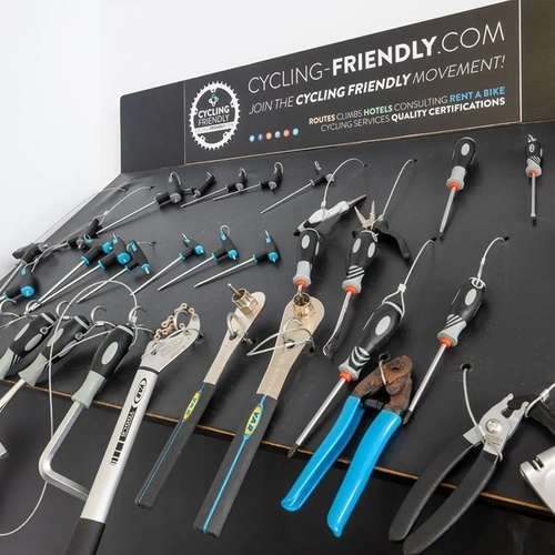 varias herramientas están colgadas en una pared junto a un cartel que dice 