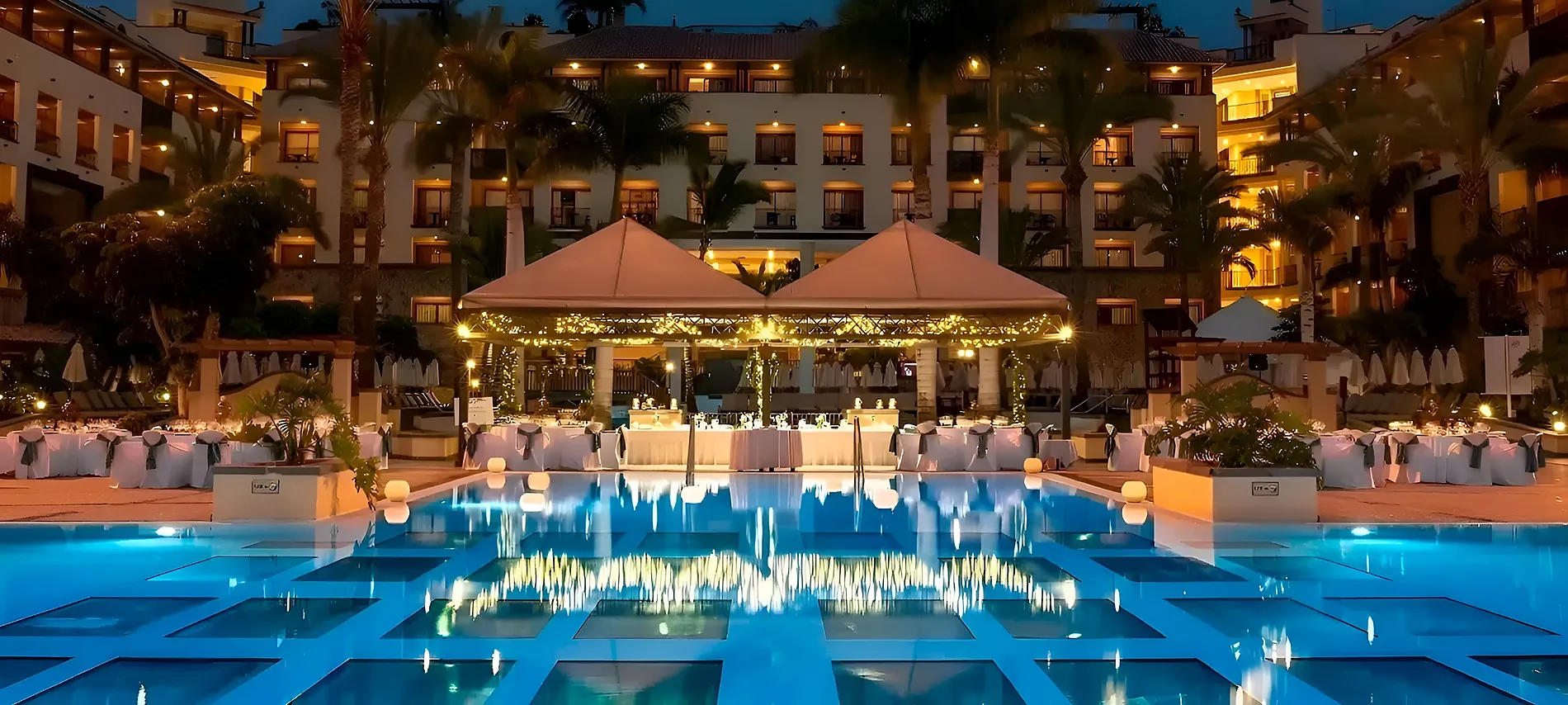 Piscina y mesas decoradas para un evento en hotel Eventos y reuniones en GF Hoteles | GF Hoteles al atardecer.