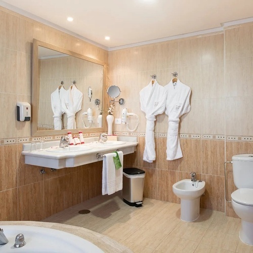 a bathroom with a sink toilet and bidet