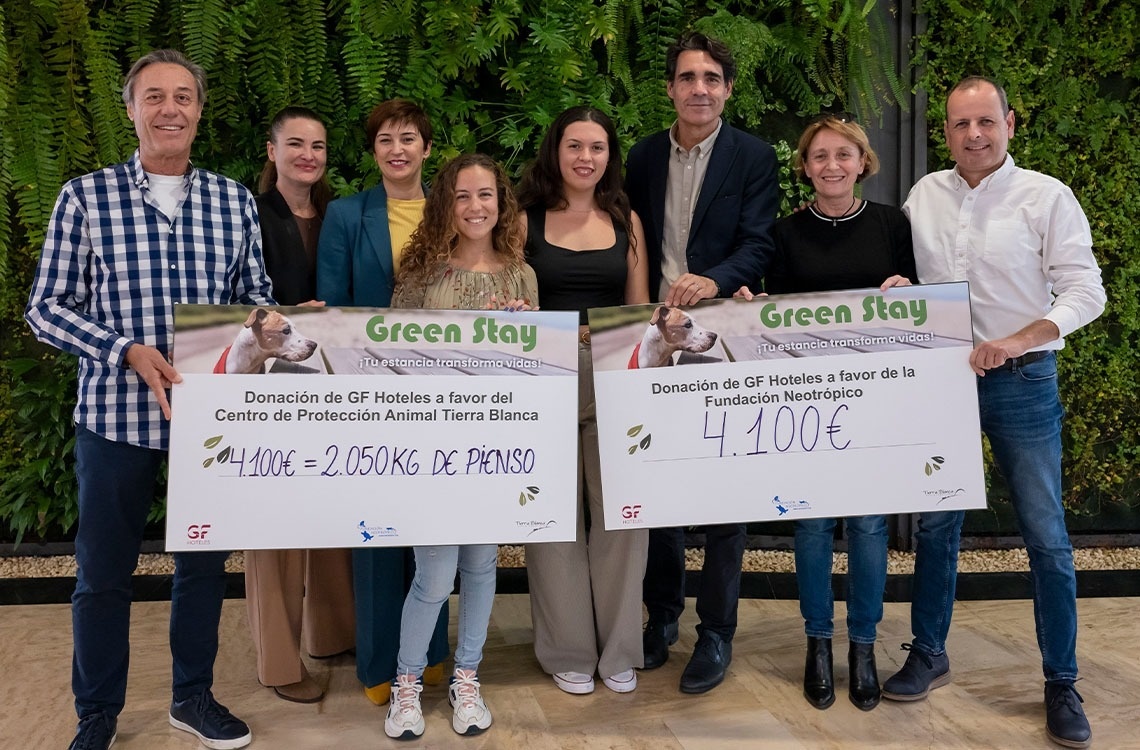 un grupo de personas sostiene cheques que dicen green stay