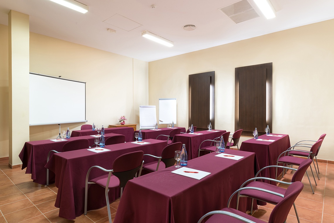 Corporate conference room with red chairs and whiteboards.