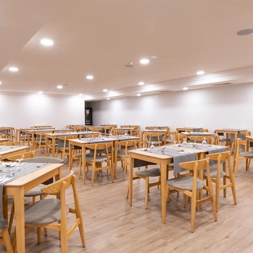 una larga fila de mesas y sillas en un restaurante