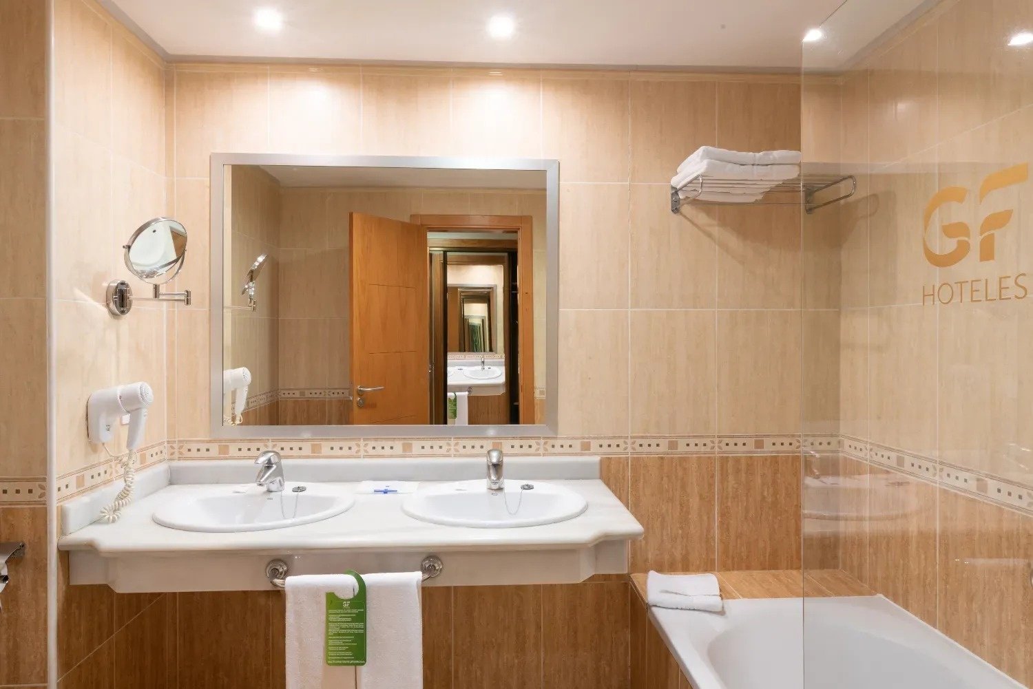 un baño de hotel con dos lavabos y una bañera