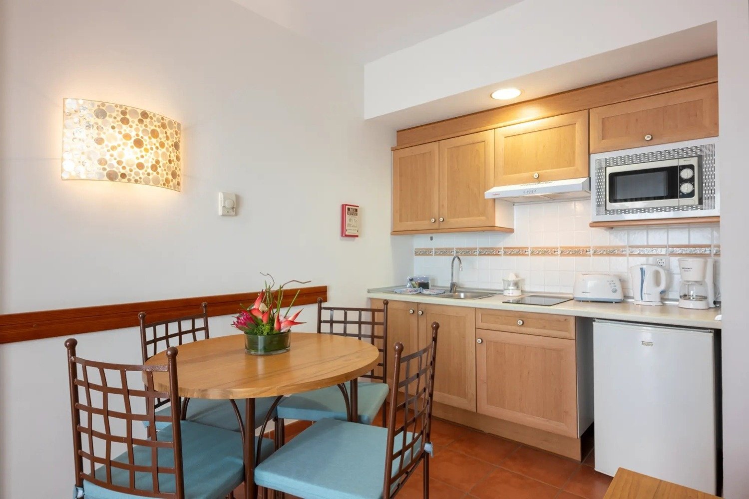 una pequeña cocina con una mesa y sillas y un microondas