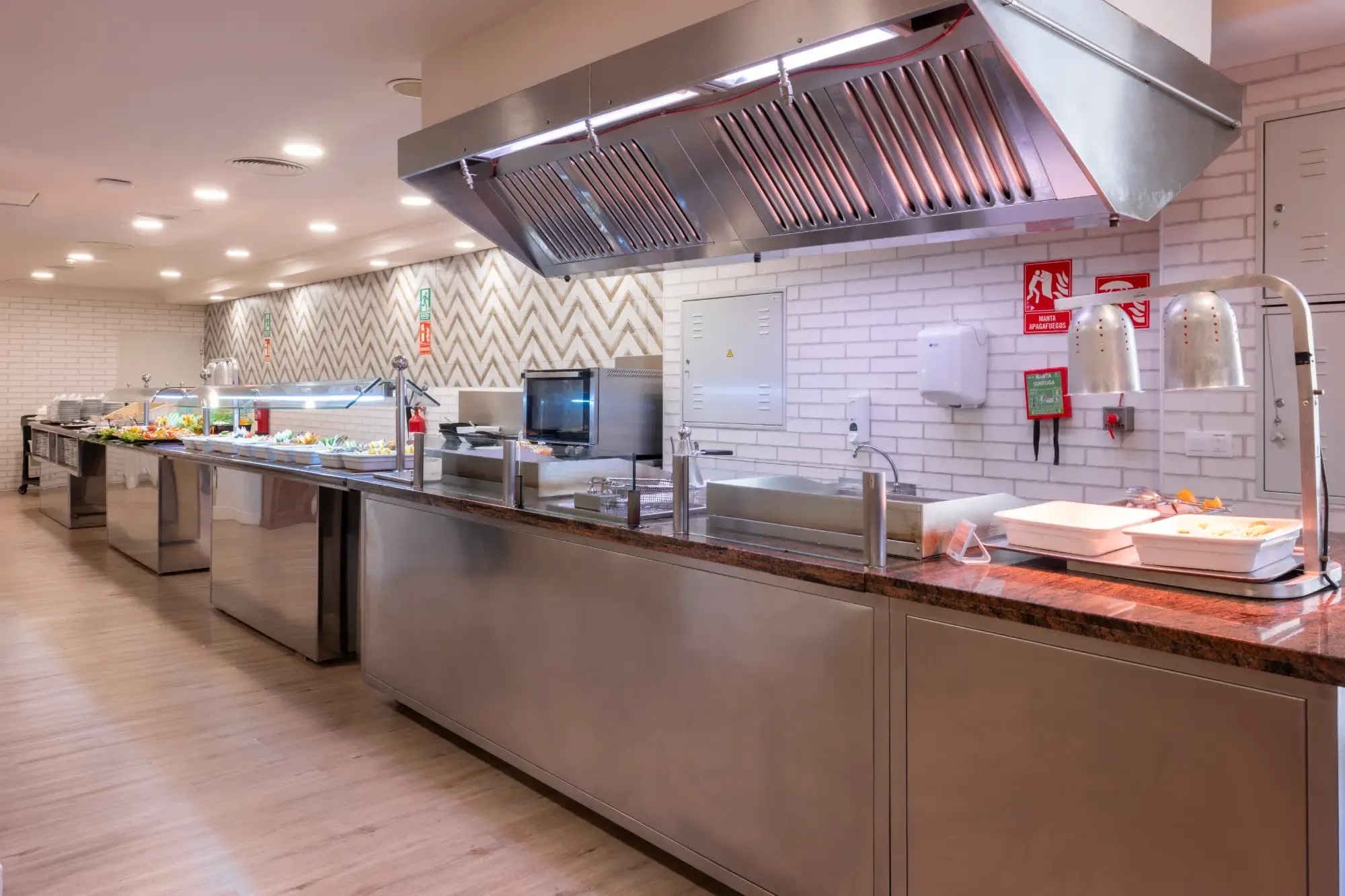 una cocina con una pared de ladrillos blancos y una señal de advertencia de incendios