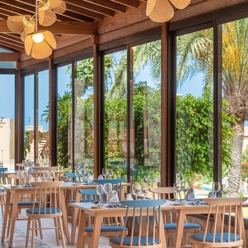 un restaurante con mesas y sillas y grandes ventanas