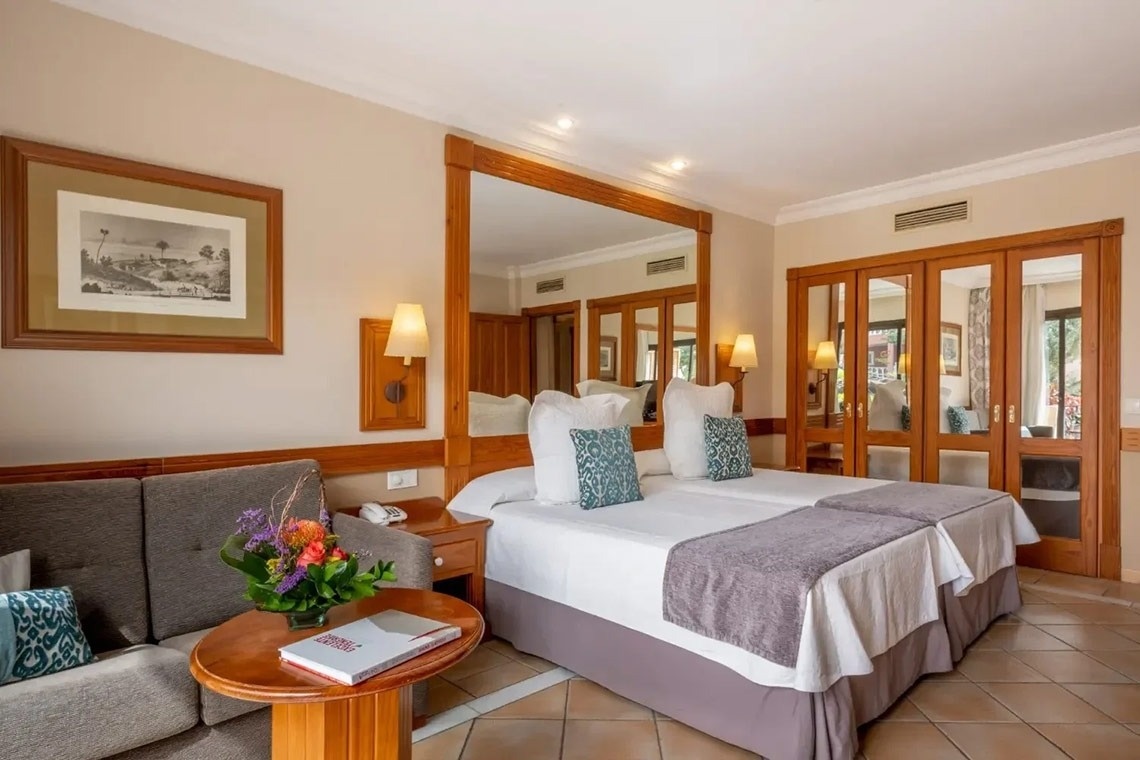 una habitación de hotel con dos camas y un sofá