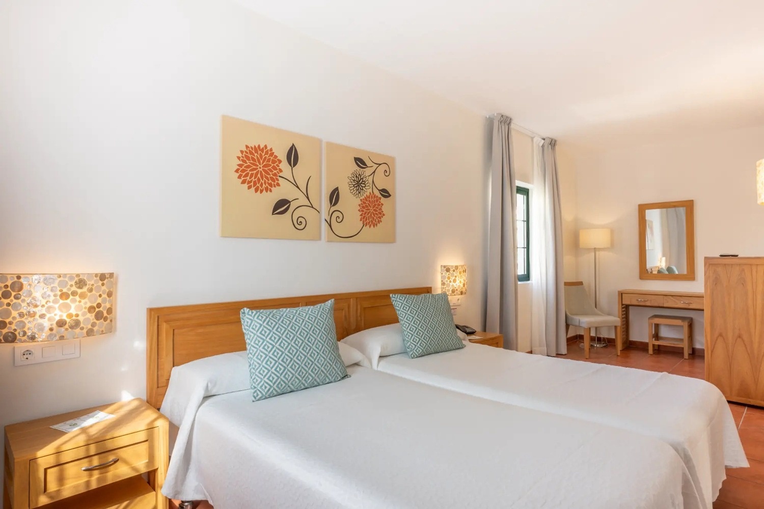 una habitación con dos camas y un espejo