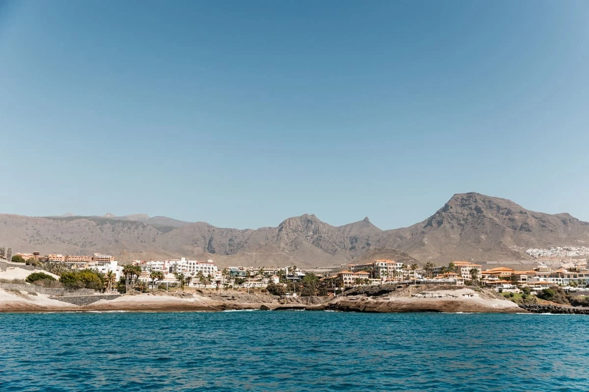 Costa de Tenerife con complejos turísticos y montañas, ideal para tu GF Hoteles.