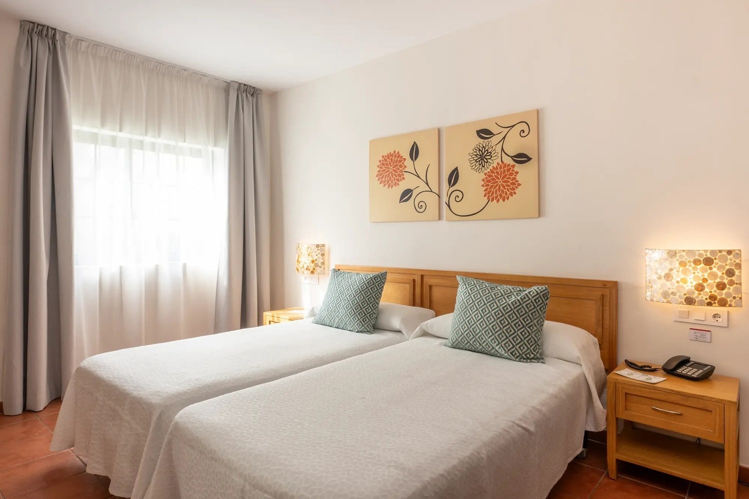 un dormitorio con dos camas y dos cuadros en la pared