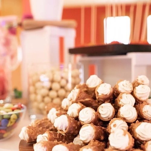 un montón de cannoli con glaseado blanco sobre una mesa