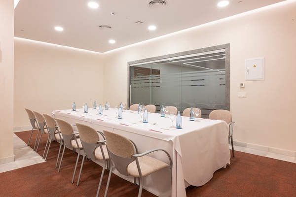 Sala de reuniones moderna con pantalla GF: Victoria y mesa de cristal.