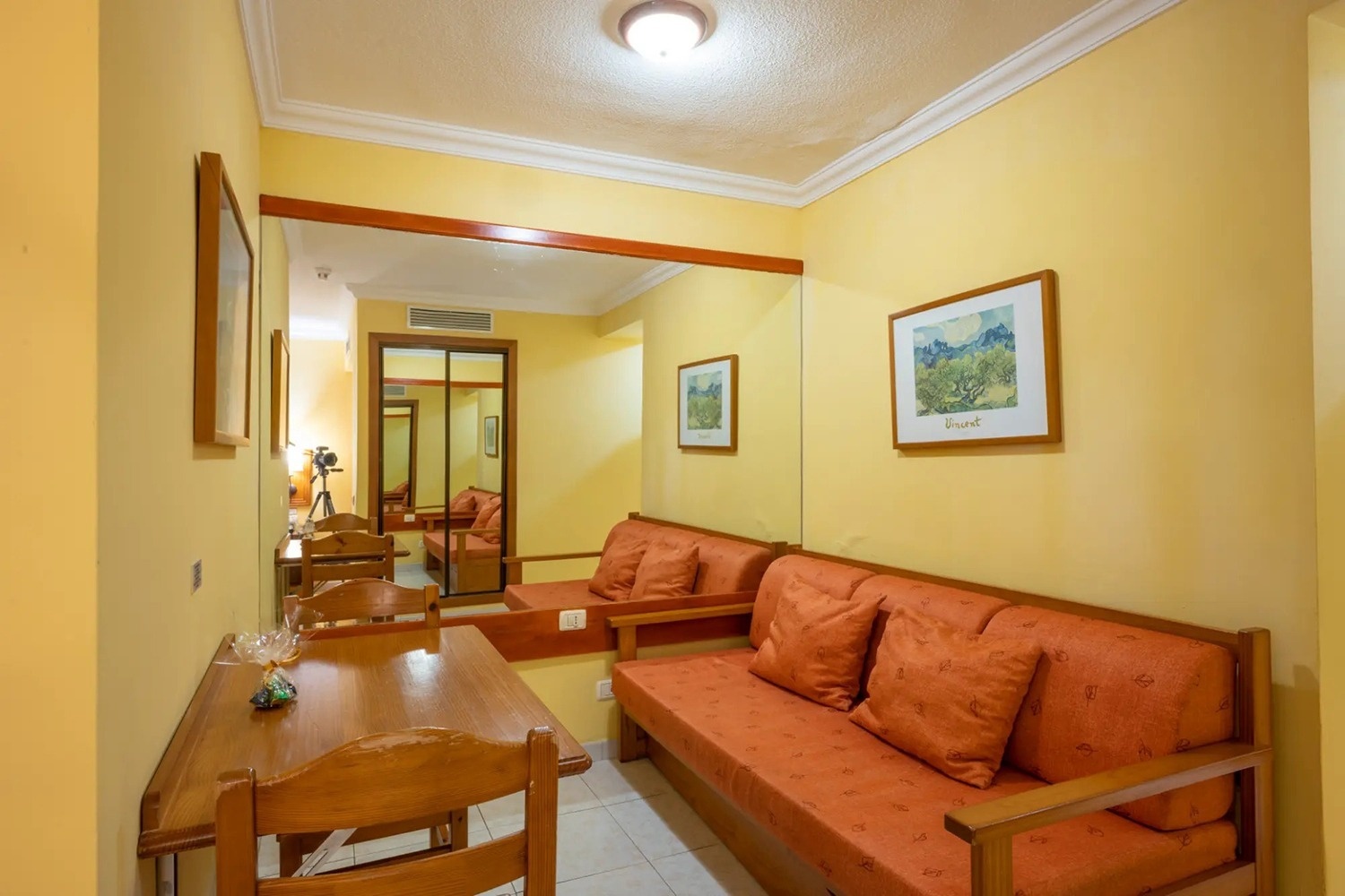 una habitación amarilla con un sofá y una mesa