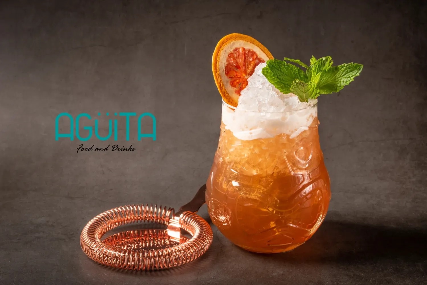 a drink in a glass with the words aguila food and drinks behind it
