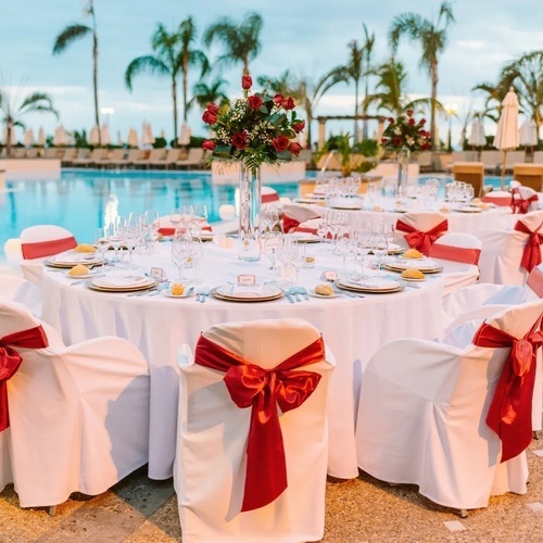 las mesas y sillas están decoradas con lazos rojos y blancas