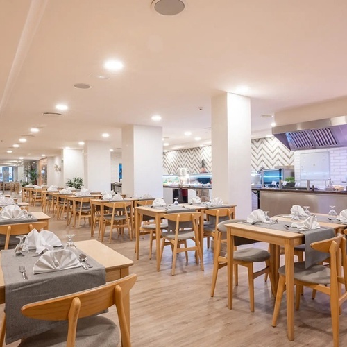 un restaurante lleno de mesas y sillas con una señal de extintor en la pared