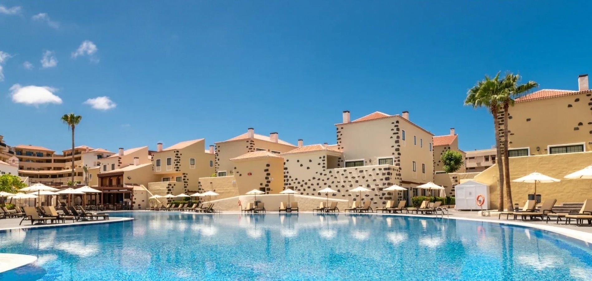 a swimming pool with umbrellas and chairs around it