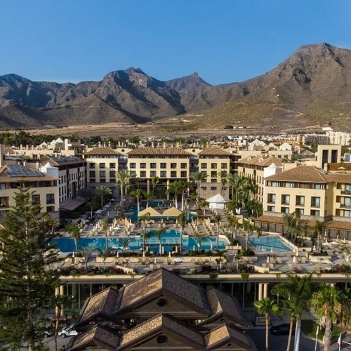 una vista aérea de un gran hotel con montañas en el fondo