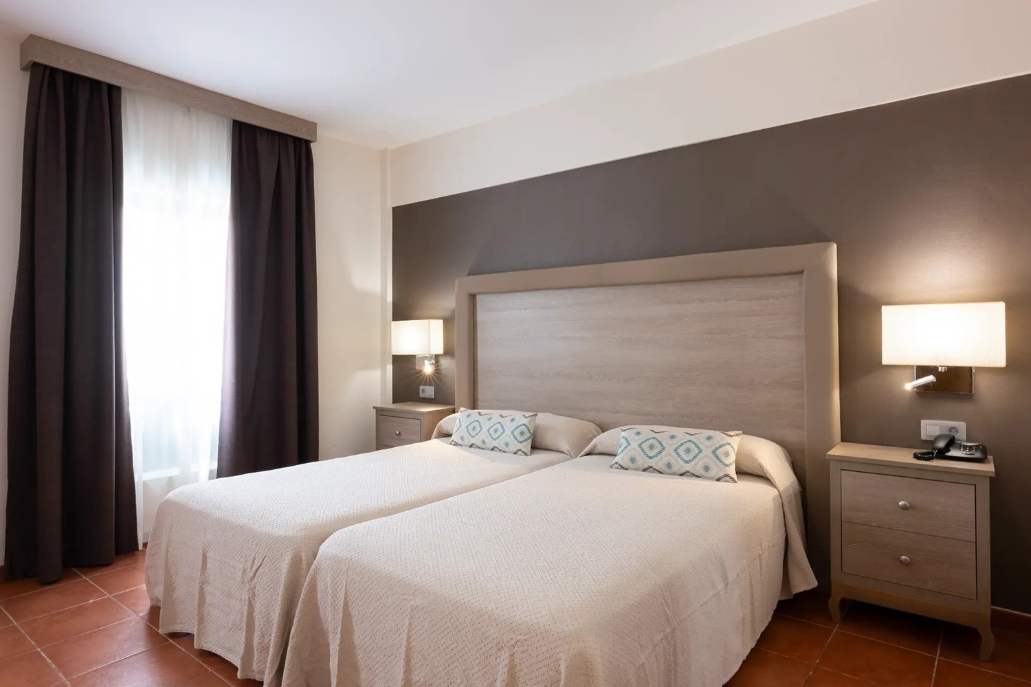 una habitación con dos camas y dos mesitas de noche