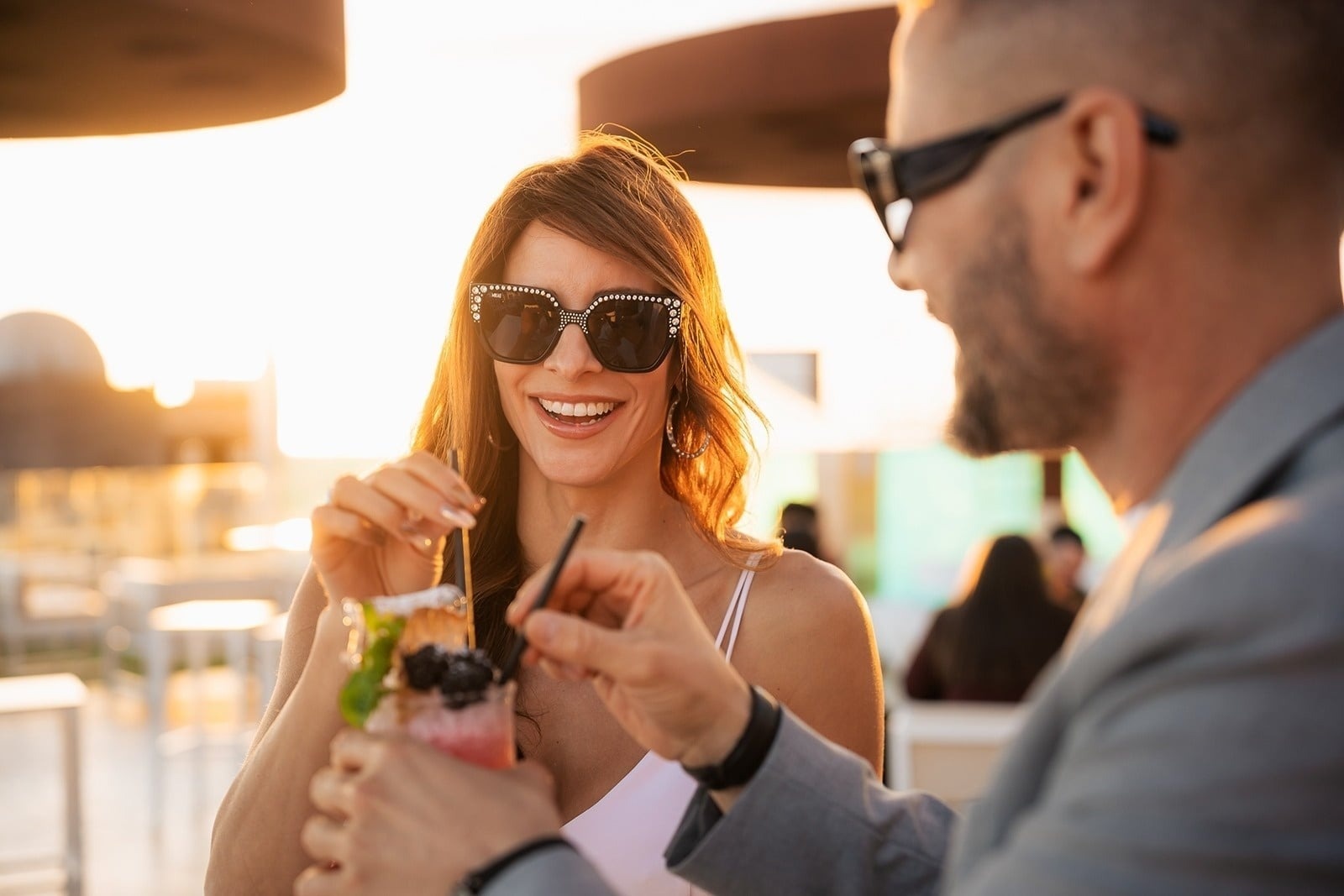a woman giving a business card to a man in front of a noelia hotel sign