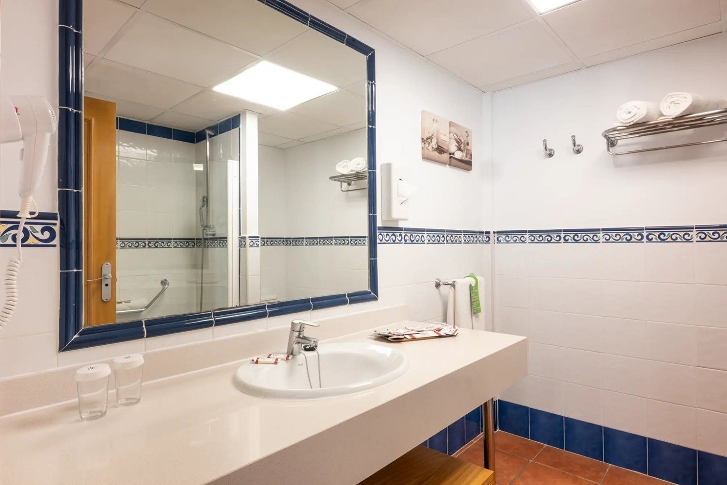 un baño con azulejos blancos y azules y un lavabo