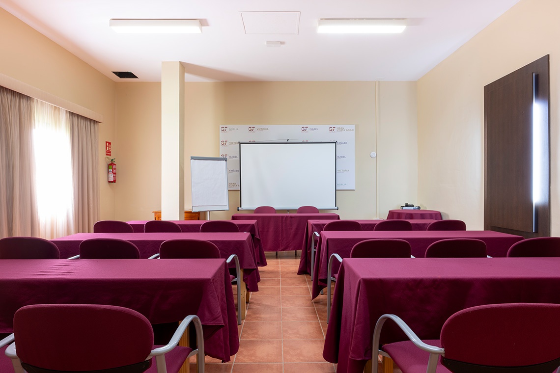 Sala de conferencias GF: Corporativa con mesas, sillas y proyector.