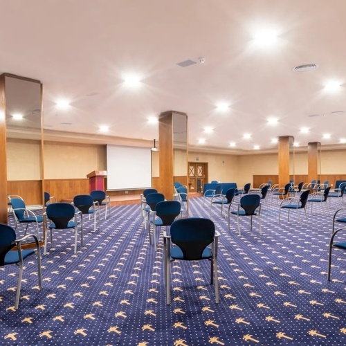 una sala de conferencias llena de sillas y un proyector